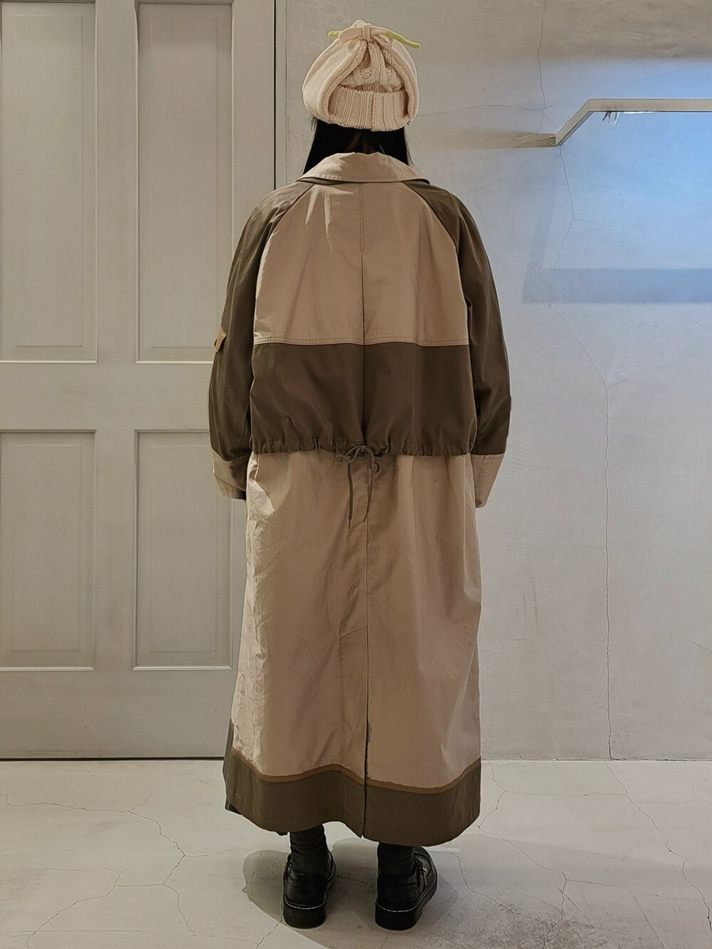 ホワイト系のTシャツ/カットソー、ベージュ系のステンカラーコート、グレー系のスカートを着用したレディースの秋コーディネートの3枚目の写真