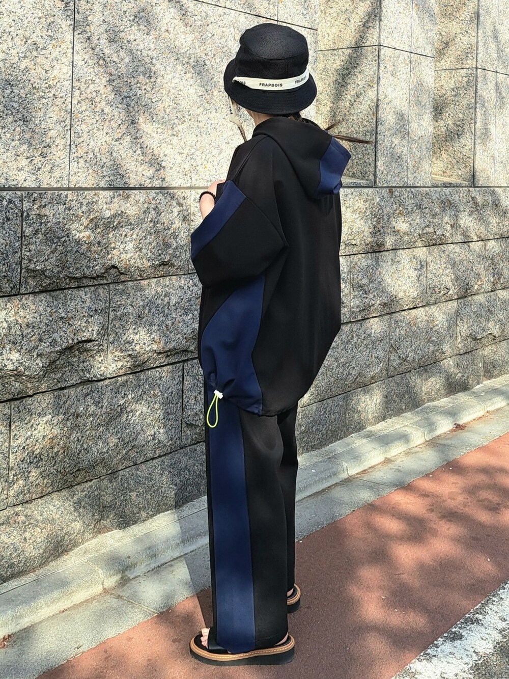 ブラック系のパーカー、ブラック系のその他パンツ、ブラック系のハットを着用したレディースの春コーディネートの2枚目の写真