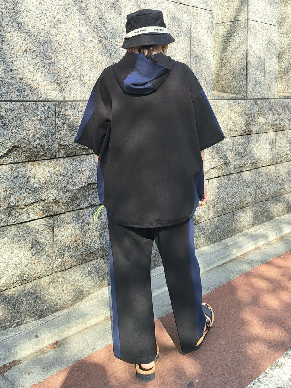 ブラック系のパーカー、ブラック系のその他パンツ、ブラック系のハットを着用したレディースの春コーディネートの3枚目の写真