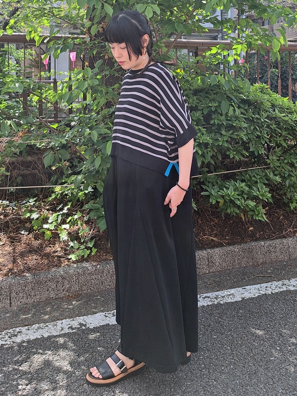 ブラック系のワンピースを着用したレディースの春コーディネートの2枚目の写真