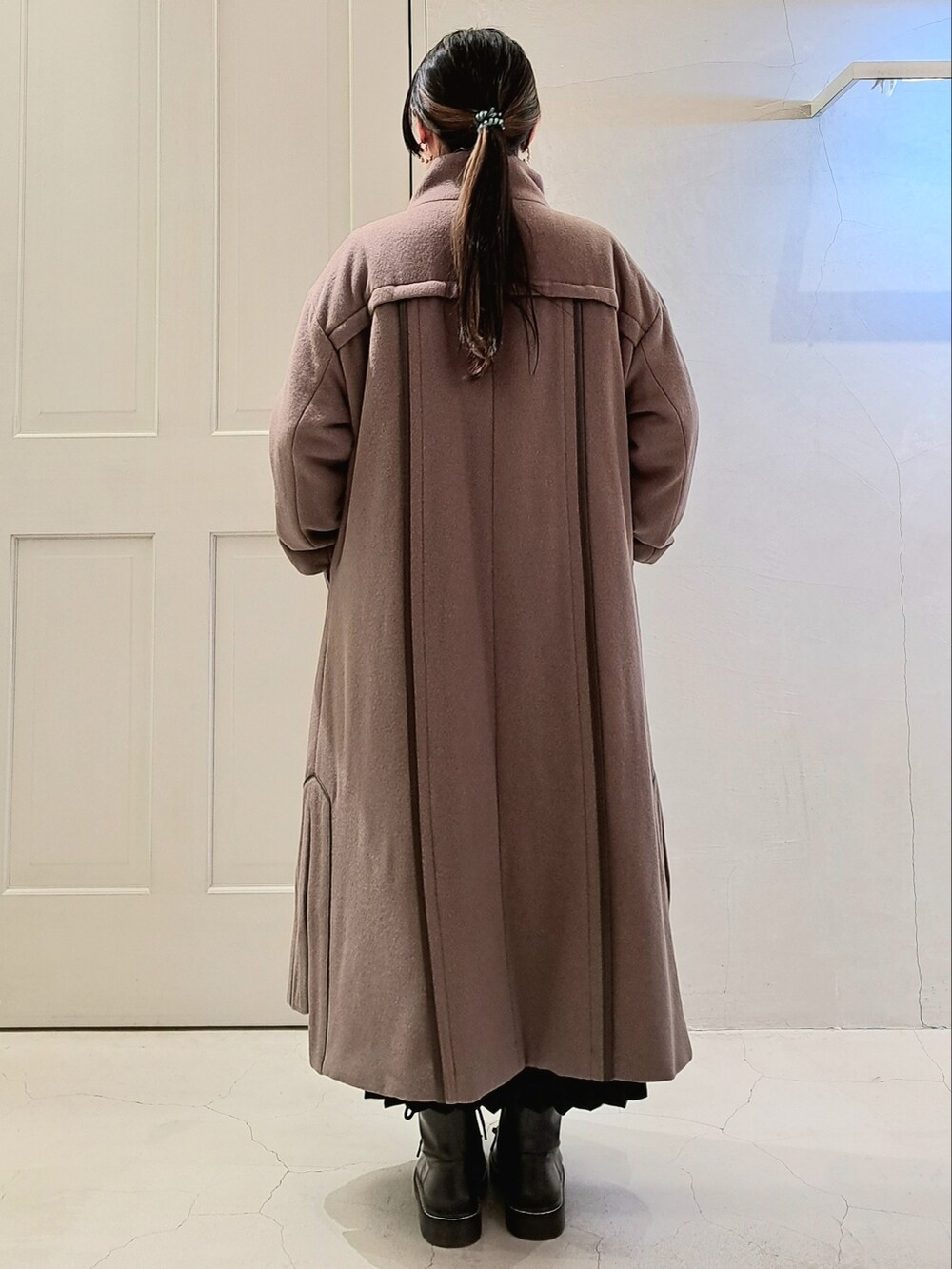 ブラウン系のその他アウター、ブラック系のスカート、ブラック系のブーツを着用したレディースの秋コーディネートの3枚目の写真