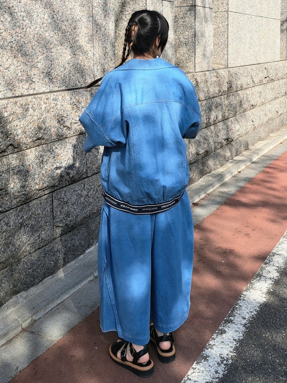 ブルー系のデニムジャケット、グレー系のニット/セーター、ブルー系のその他パンツを着用したレディースの春コーディネートの3枚目の写真