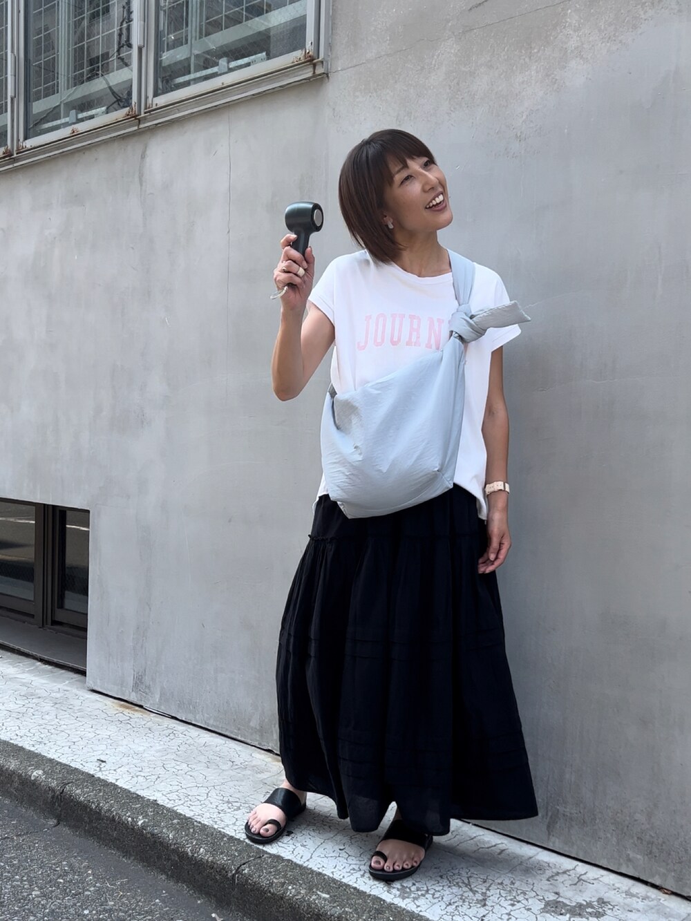 グリーン系のショルダーバッグ、ブラック系のスカート、グレー系の生活家電を着用したレディースの夏コーディネートの2枚目の写真