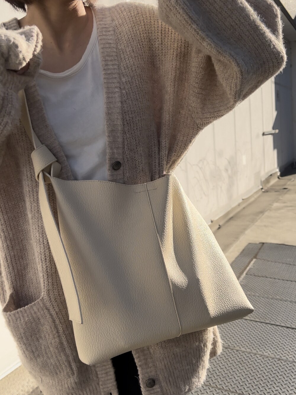 ブラック系のその他パンツ、ベージュ系のカーディガン/ボレロ、シルバー系のショルダーバッグを着用したレディースの冬コーディネートの4枚目の写真