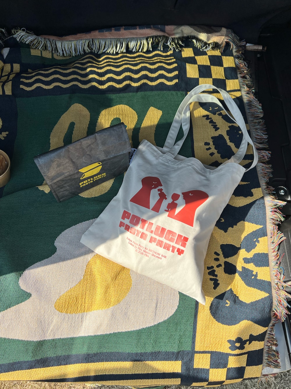 ベージュ系のトートバッグ、グリーン系のブランケットを着用したレディースの春コーディネートの3枚目の写真