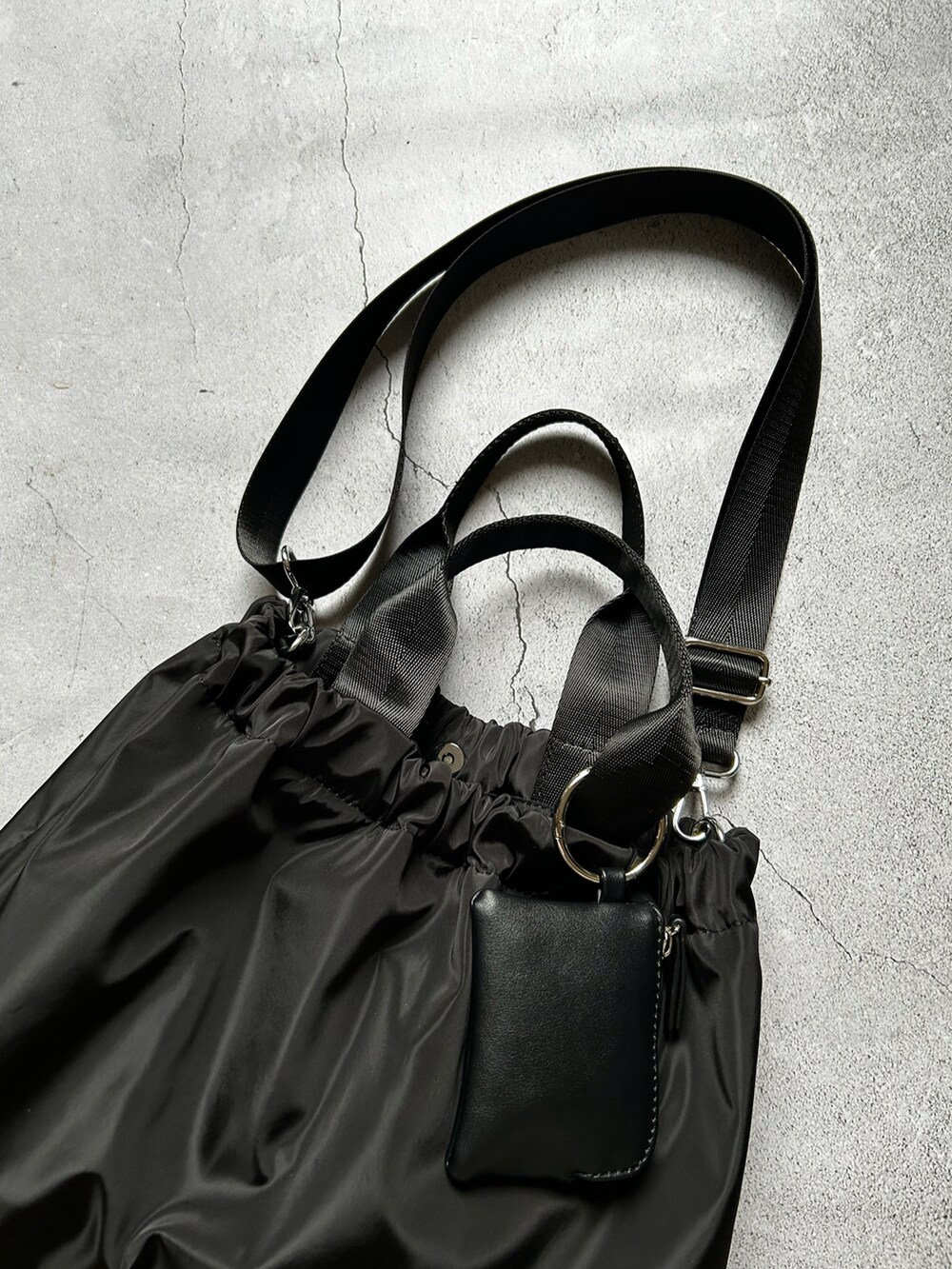 ブラック系のショルダーバッグ、ベージュ系の財布、ブラック系のカメラ/カメラグッズを着用したレディースの春コーディネートの5枚目の写真