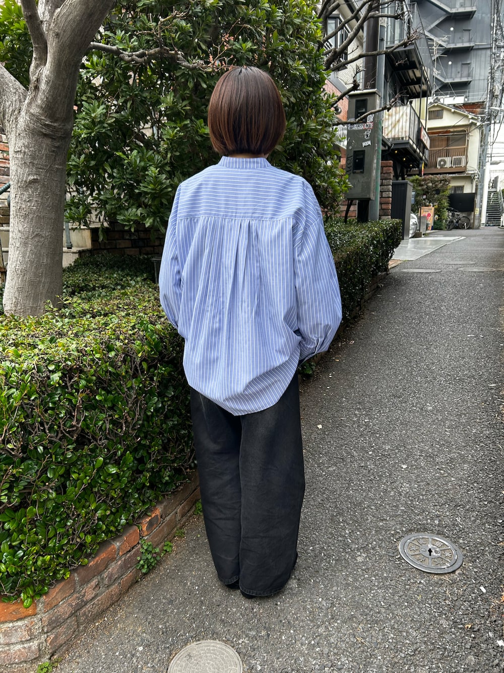 ブルー系のシャツ/ブラウス、ブラック系のデニムパンツを着用したレディースの春コーディネートの3枚目の写真