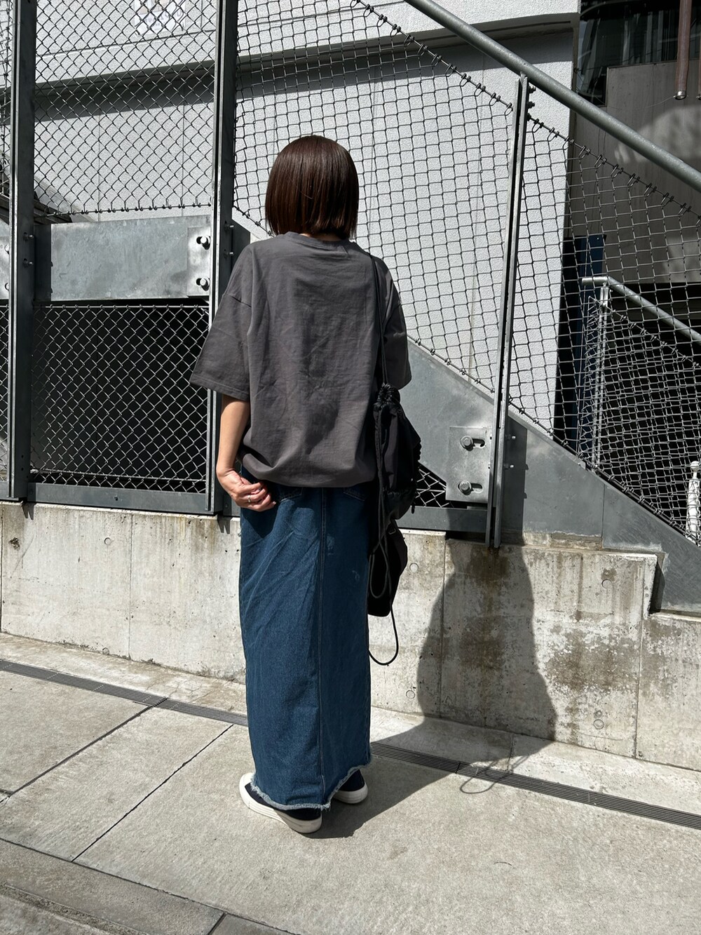 グレー系のTシャツ/カットソー、ブラック系のバックパック/リュック、グレー系のキャップを着用したレディースの春コーディネートの3枚目の写真