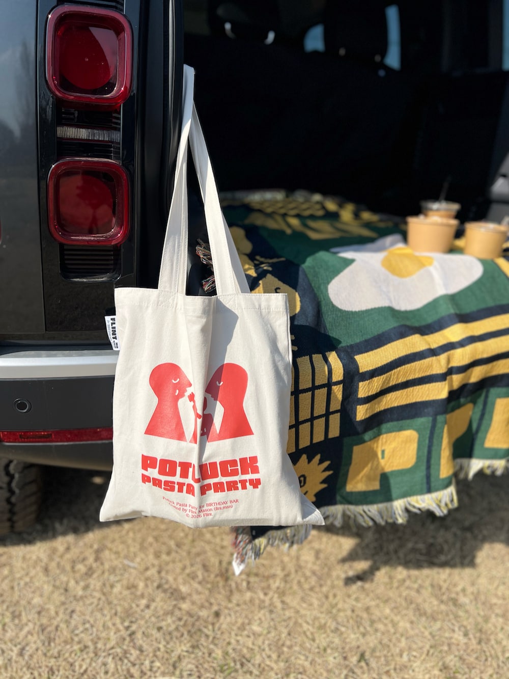 ベージュ系のトートバッグ、グリーン系のブランケットを着用したレディースの春コーディネートの2枚目の写真