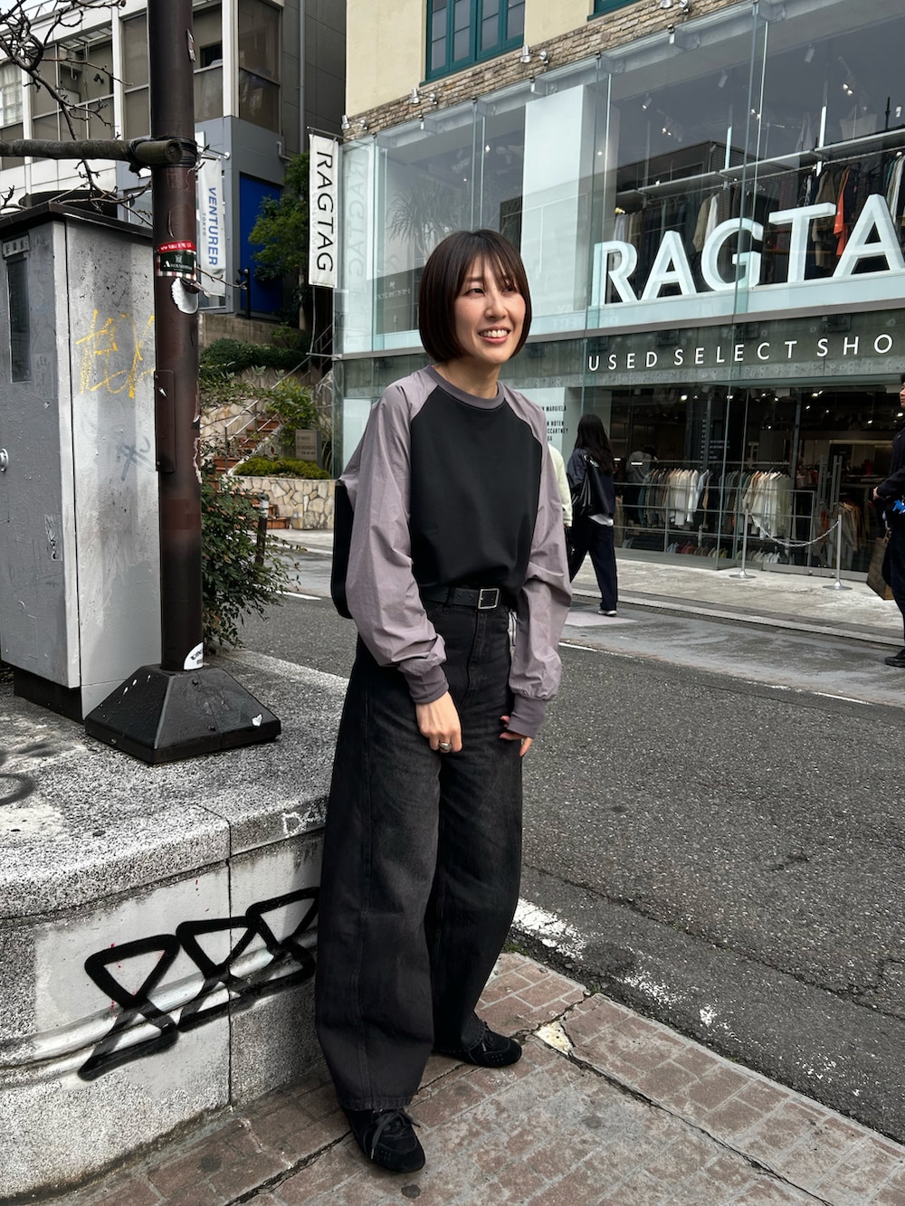 グレー系のTシャツ/カットソー、ブラック系のデニムパンツを着用したレディースの春コーディネートの2枚目の写真