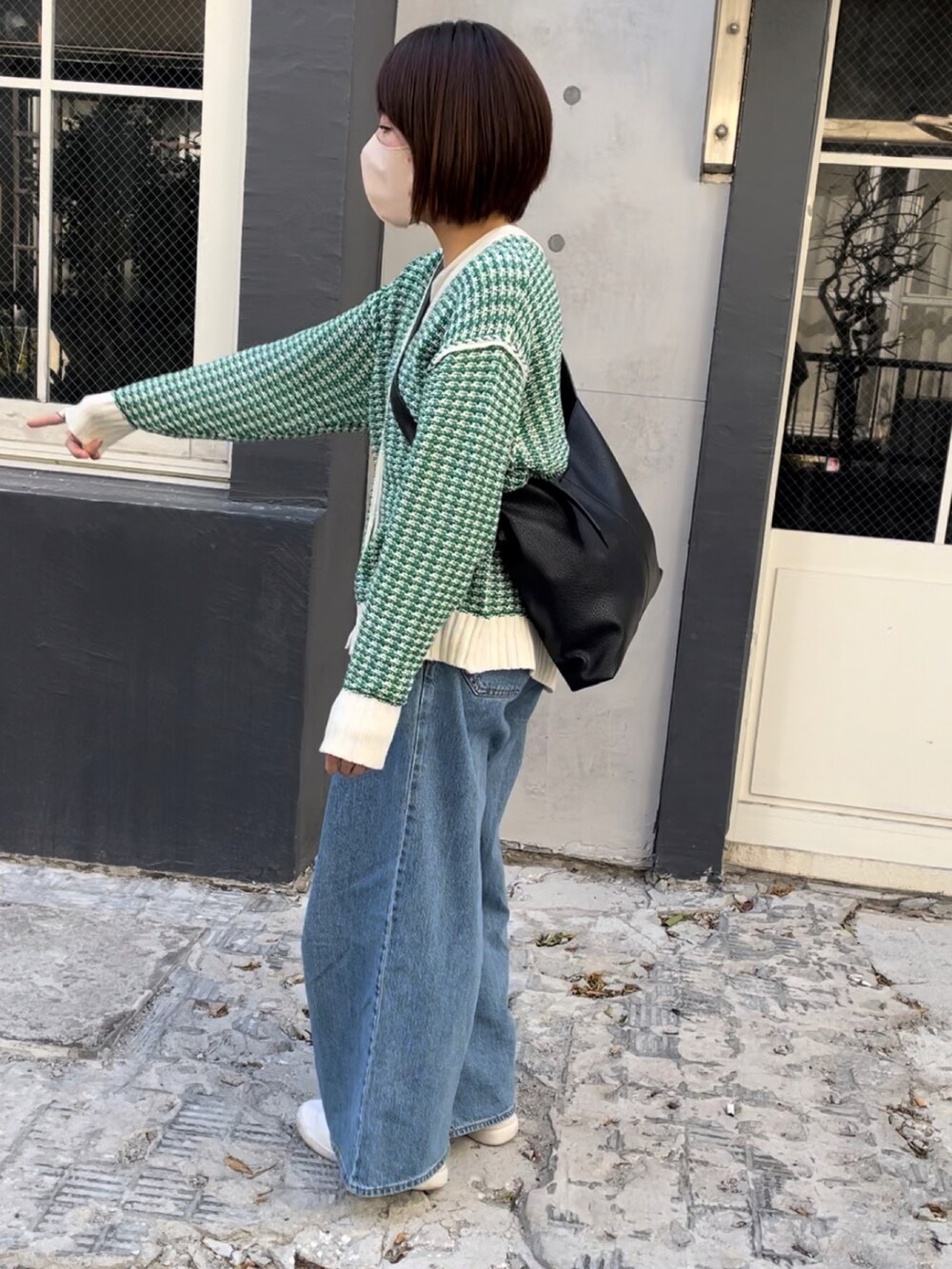 ブラック系のショルダーバッグ、グリーン系のカーディガン/ボレロ、その他のデニムパンツを着用したレディースの冬コーディネートの3枚目の写真