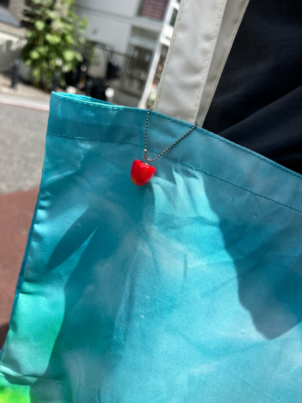 ブルー系のトートバッグ、ブルー系のパンツを着用したレディースの夏コーディネートの3枚目の写真