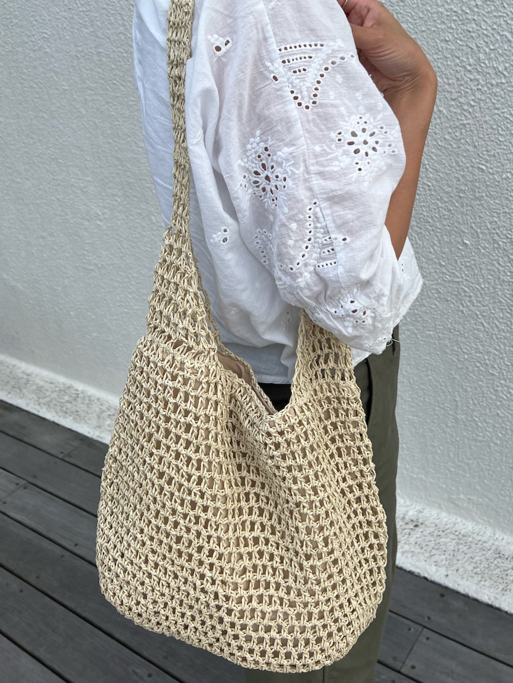 グレー系のショルダーバッグ、グリーン系のその他パンツ、ホワイト系のトップスを着用したレディースの春コーディネートの2枚目の写真