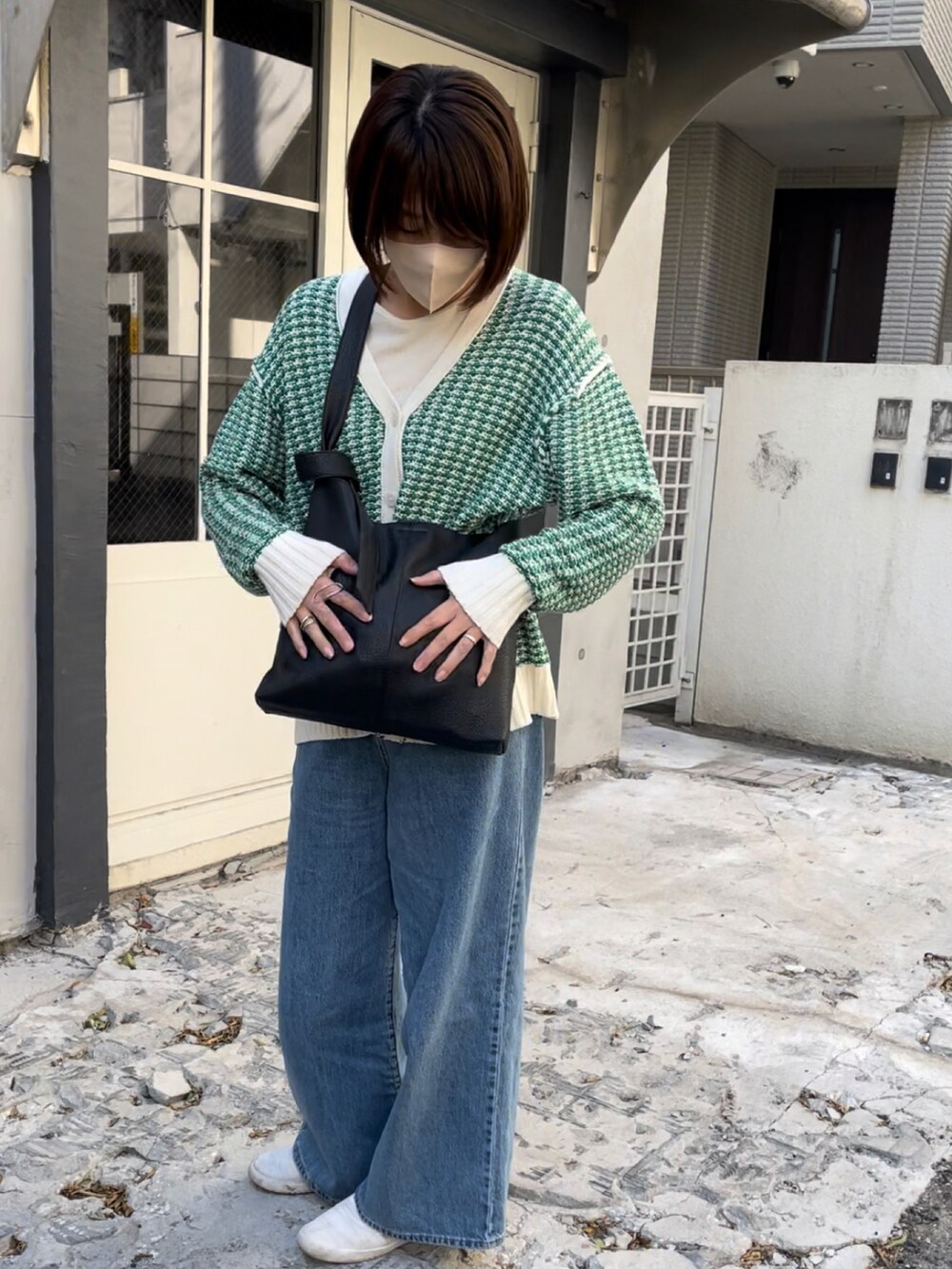 ブラック系のショルダーバッグ、グリーン系のカーディガン/ボレロ、その他のデニムパンツを着用したレディースの冬コーディネートの2枚目の写真