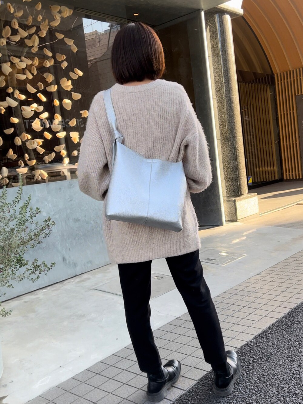 ブラック系のその他パンツ、ベージュ系のカーディガン/ボレロ、シルバー系のショルダーバッグを着用したレディースの冬コーディネートの2枚目の写真