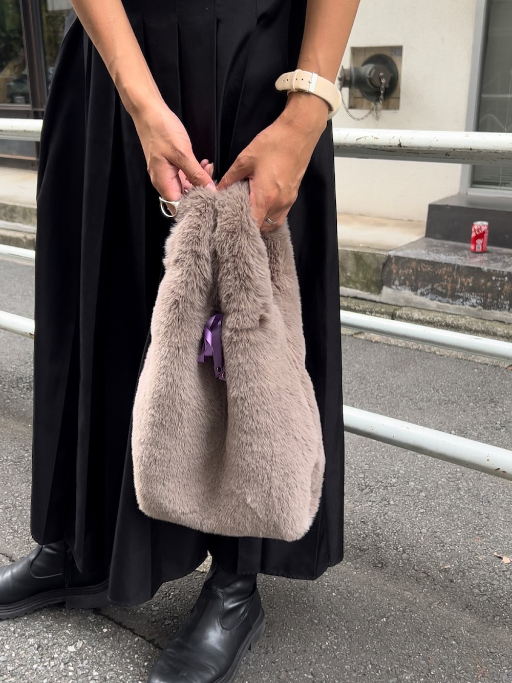 グレー系のハンドバッグ、ブラック系のスカート、グレー系のTシャツ/カットソーを着用したレディースの秋コーディネートの2枚目の写真