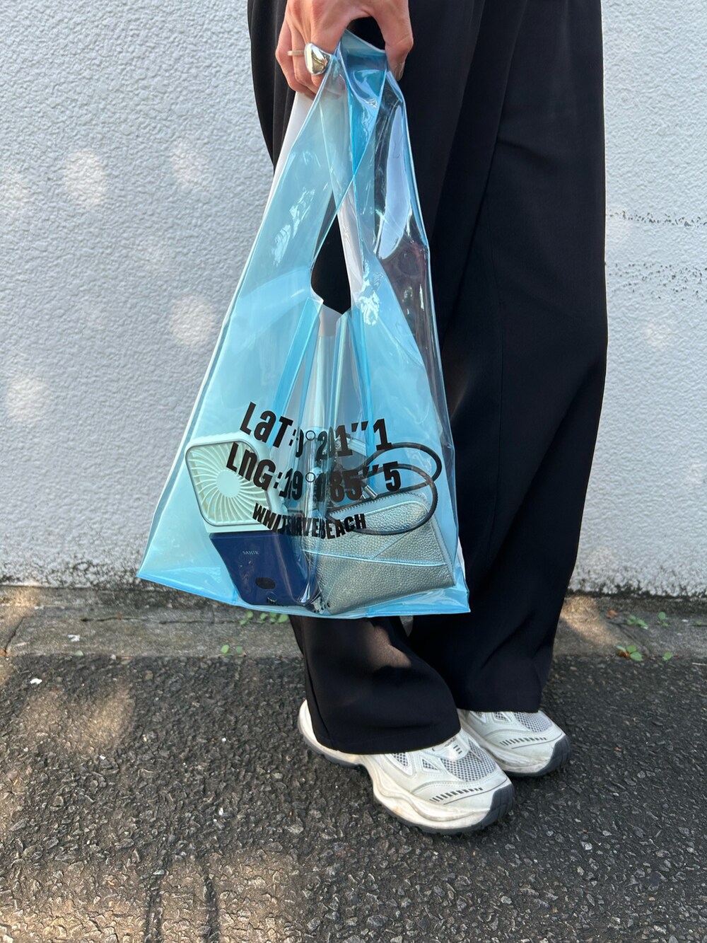 ブルー系のトートバッグ、ブラック系のスラックス、ホワイト系の生活家電を着用したレディースの夏コーディネートの2枚目の写真