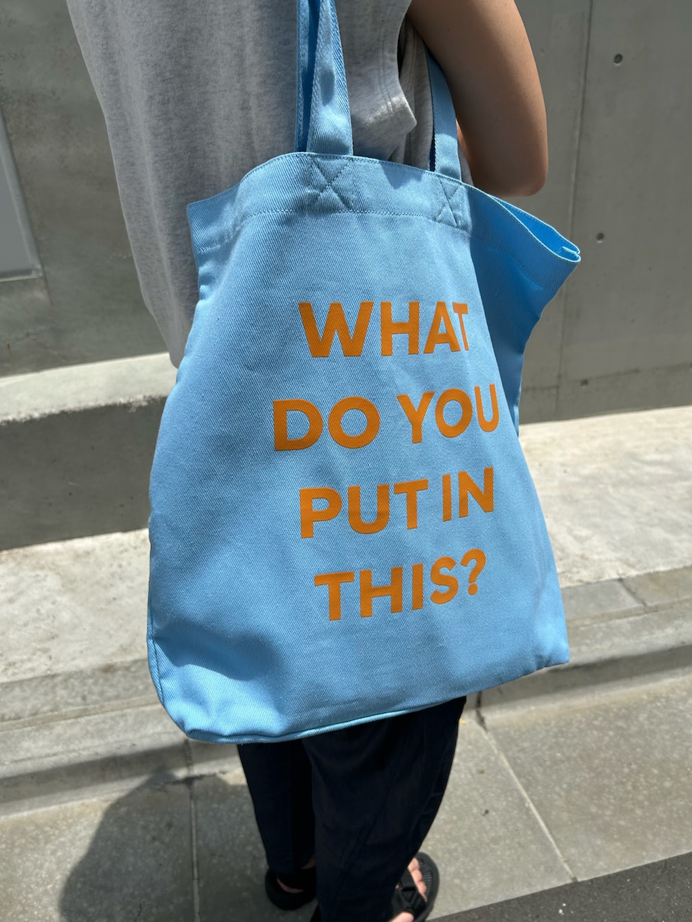 ブルー系のトートバッグを着用したレディースの夏コーディネートの3枚目の写真