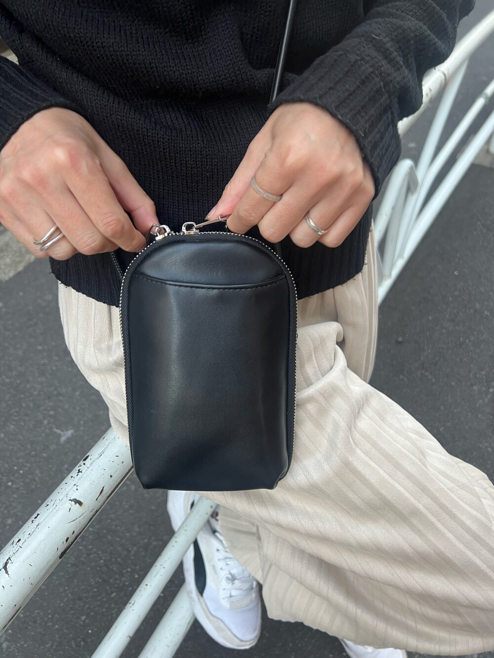 ブラック系のトップス、ブラック系のトップス、ホワイト系のショルダーバッグを着用したレディースの春コーディネートの2枚目の写真