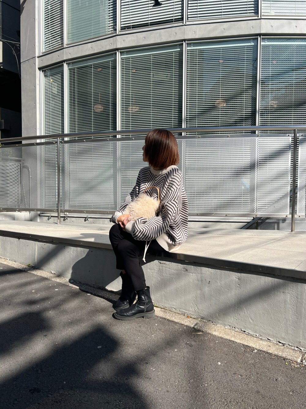 ホワイト系のトートバッグ、ブラック系のニット/セーター、ブラック系のその他パンツを着用したレディースの秋コーディネートの2枚目の写真