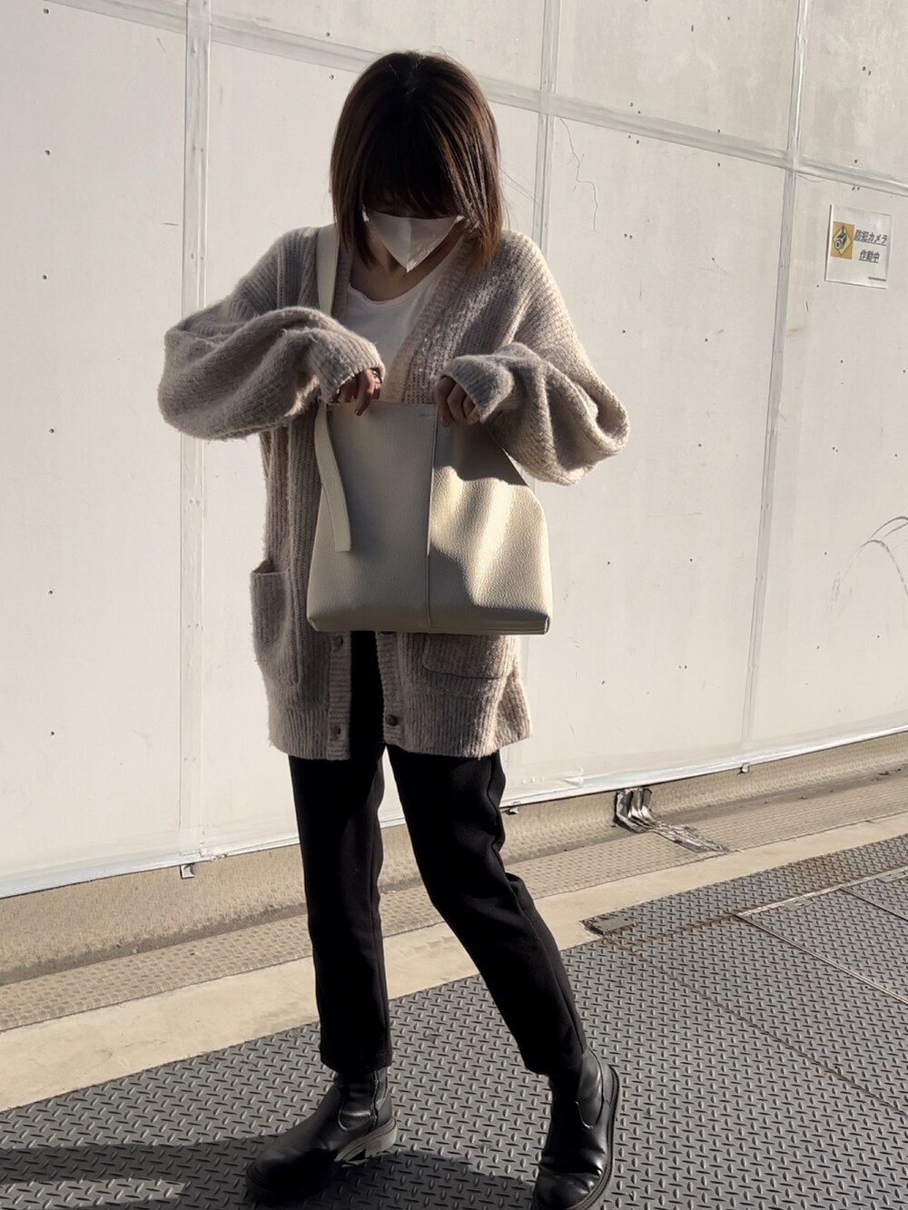 ブラック系のその他パンツ、ベージュ系のカーディガン/ボレロ、シルバー系のショルダーバッグを着用したレディースの冬コーディネートの3枚目の写真