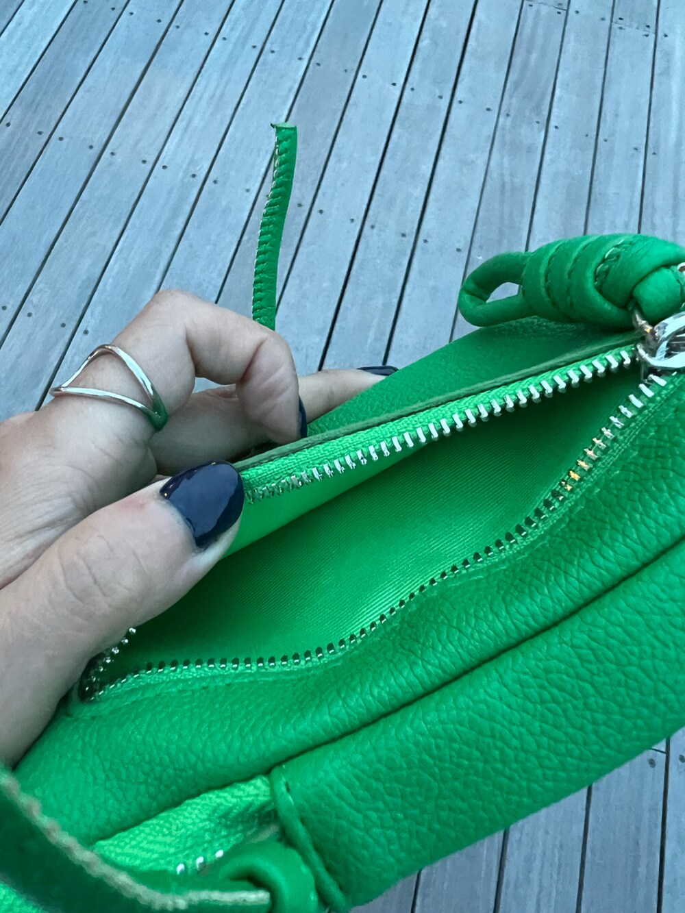 グリーン系のショルダーバッグ、ブラック系のスカート、ブラック系のTシャツ/カットソーを着用したレディースの春コーディネートの2枚目の写真