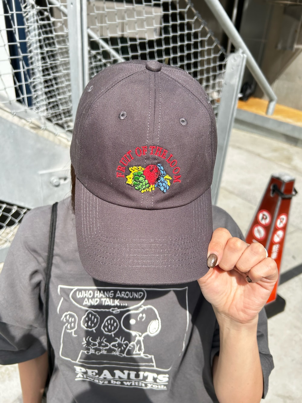 グレー系のTシャツ/カットソー、ブラック系のバックパック/リュック、グレー系のキャップを着用したレディースの春コーディネートの2枚目の写真