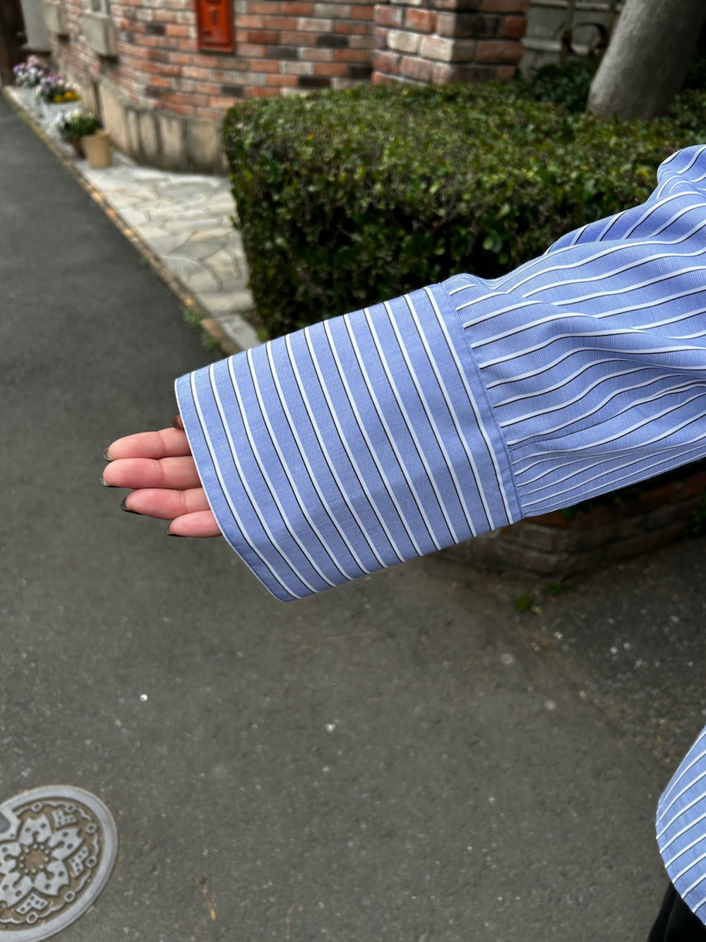 ブルー系のシャツ/ブラウス、ブラック系のデニムパンツを着用したレディースの春コーディネートの4枚目の写真