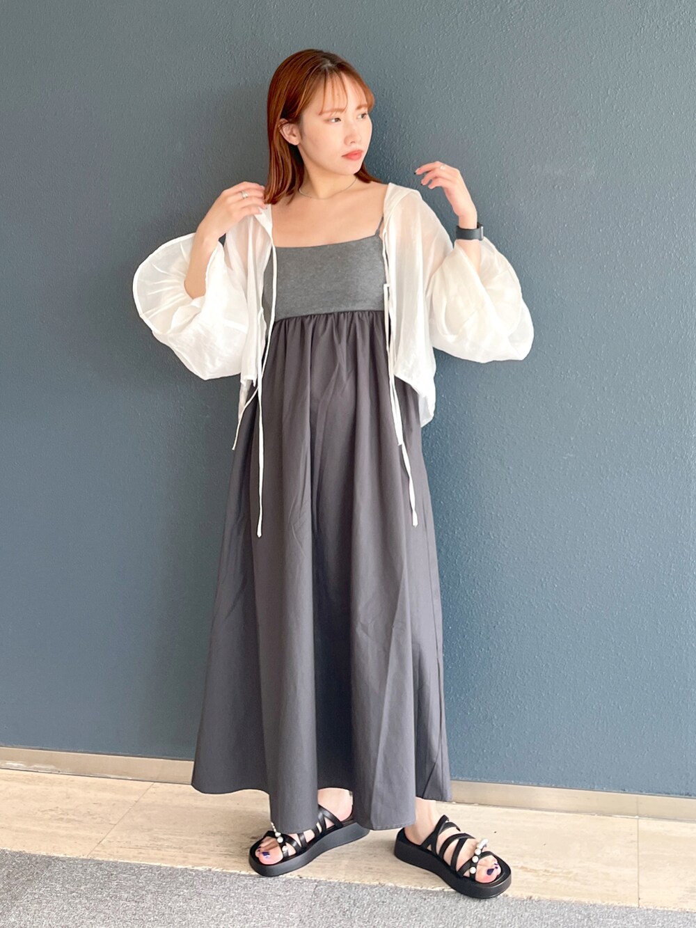 グレー系のワンピース、ホワイト系のシャツ/ブラウス、ブラック系のサンダルを着用したレディースの夏コーディネートの2枚目の写真