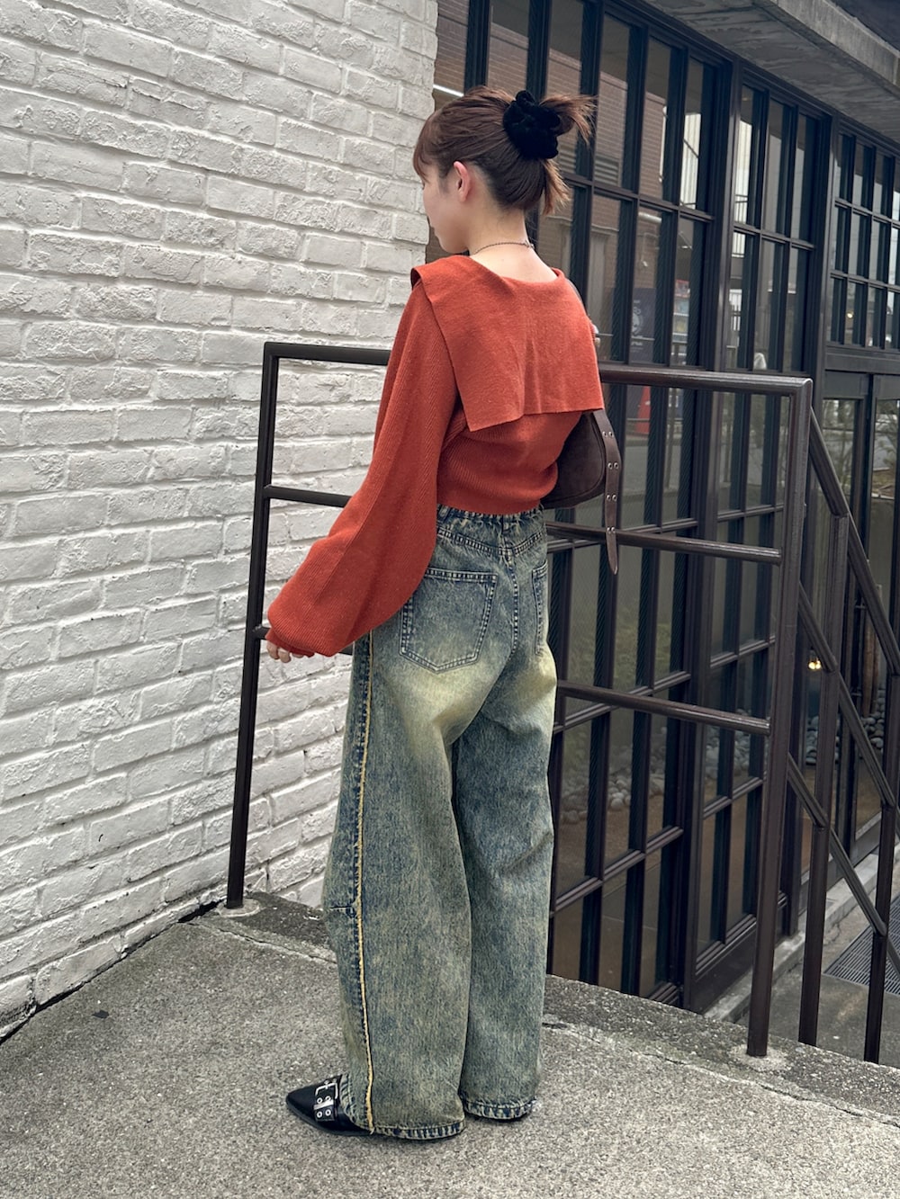 オレンジ系のカーディガン/ボレロ、ベージュ系のデニムパンツ、ブラック系のパンプスを着用したレディースの秋コーディネートの2枚目の写真