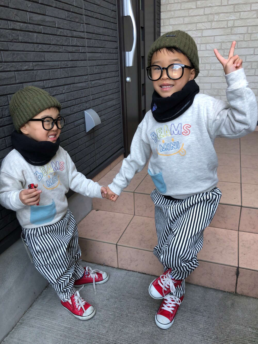 ブルー系のチノパンツ、ホワイト系のスウェット、グリーン系のニットキャップ/ビーニーを着用したキッズの冬コーディネートの2枚目の写真