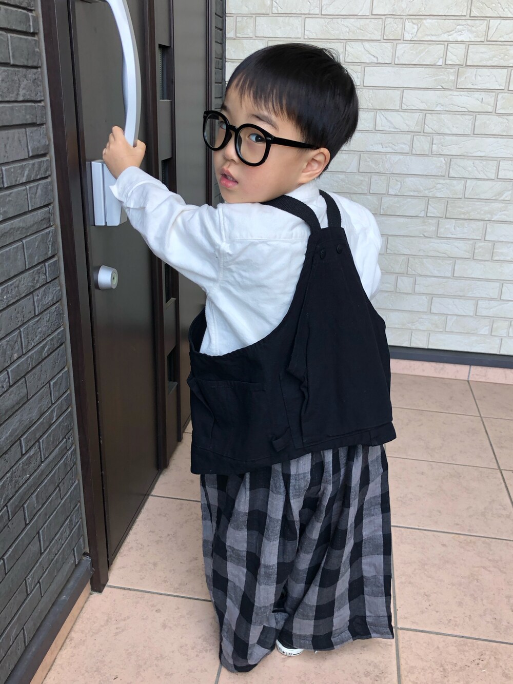 ブラック系のその他パンツ、ブラック系のベスト、ホワイト系のシャツ/ブラウスを着用したキッズの春コーディネートの4枚目の写真