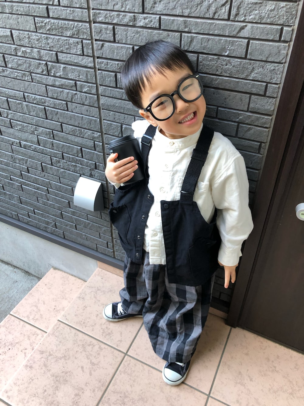 ブラック系のその他パンツ、ブラック系のベスト、ホワイト系のシャツ/ブラウスを着用したキッズの春コーディネートの3枚目の写真