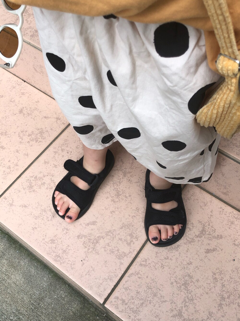 イエロー系のタンクトップ、ベージュ系のその他パンツ、ブラック系のサンダルを着用したキッズの夏コーディネートの4枚目の写真