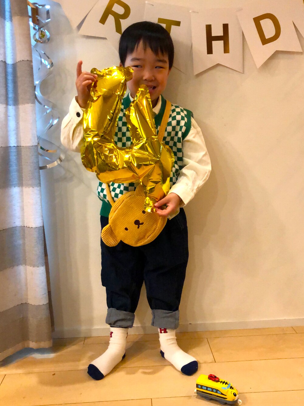 グリーン系のベスト、ブルー系のデニムパンツ、ホワイト系のシャツ/ブラウスを着用したキッズの春コーディネートの2枚目の写真