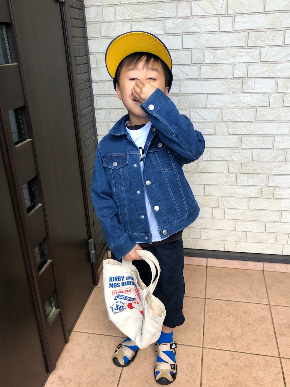 ブルー系のデニムジャケット、ホワイト系のTシャツ/カットソー、ブルー系のキャップを着用したキッズの春コーディネートの2枚目の写真