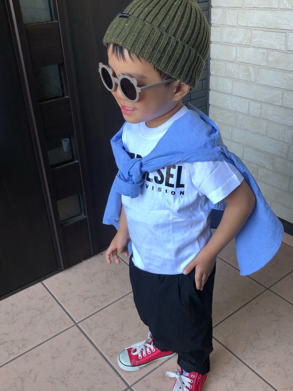 ホワイト系のTシャツ/カットソー、ブラック系のその他パンツ、レッド系のスニーカーを着用したキッズの秋コーディネートの2枚目の写真