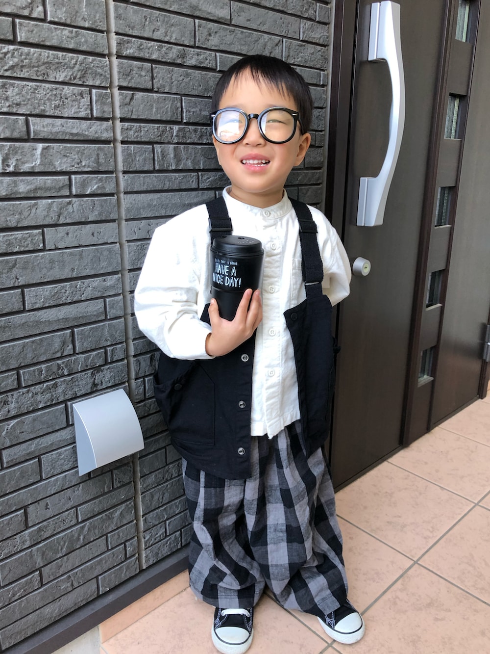 ブラック系のその他パンツ、ブラック系のベスト、ホワイト系のシャツ/ブラウスを着用したキッズの春コーディネートの2枚目の写真