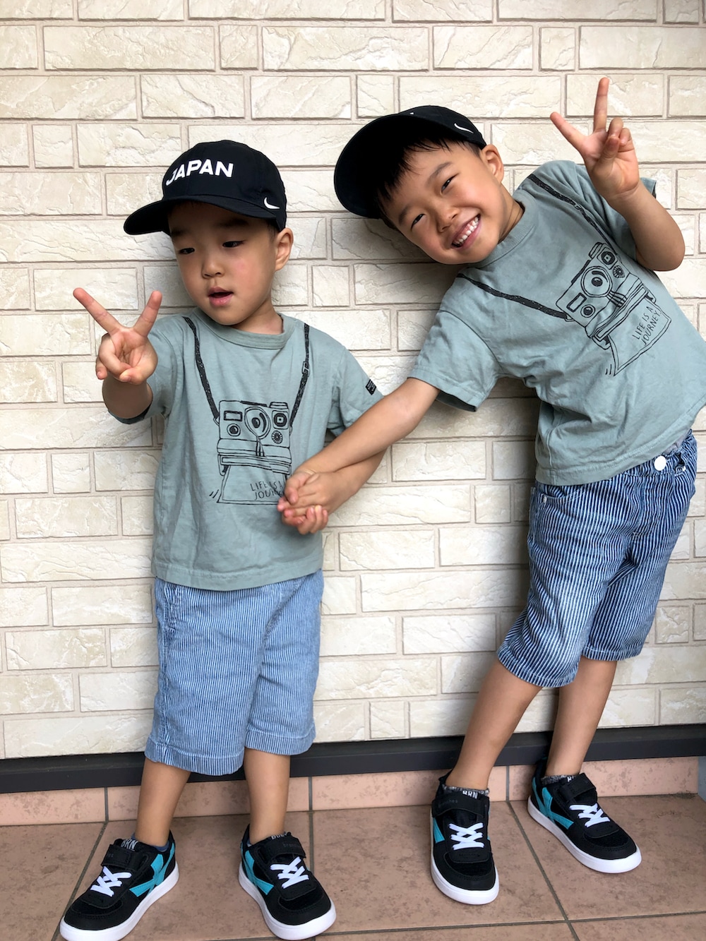 グリーン系のTシャツ/カットソー、ブルー系のパンツ、ブラック系のスニーカーを着用したキッズの秋コーディネートの2枚目の写真