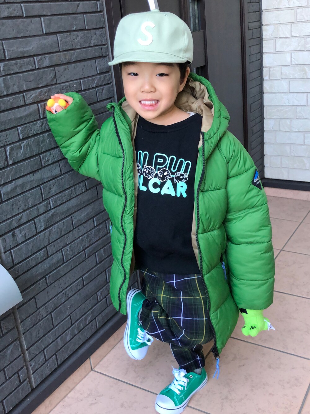 グリーン系のダウンジャケット/コート、グリーン系のその他パンツ、グリーン系のスニーカーを着用したキッズの冬コーディネートの2枚目の写真