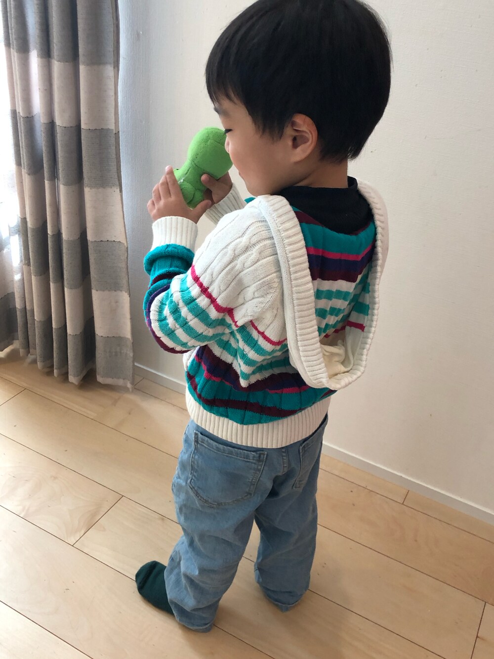 グリーン系のダウンジャケット/コート、ブルー系のデニムパンツ、その他のニット/セーターを着用したキッズの秋コーディネートの5枚目の写真