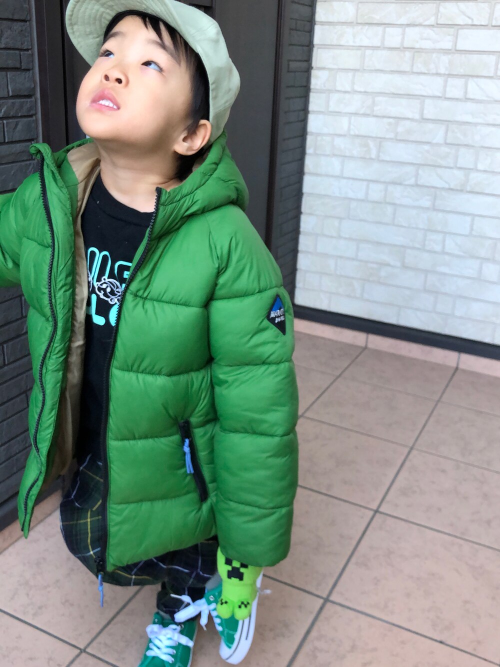 グリーン系のダウンジャケット/コート、グリーン系のその他パンツ、グリーン系のスニーカーを着用したキッズの冬コーディネートの3枚目の写真