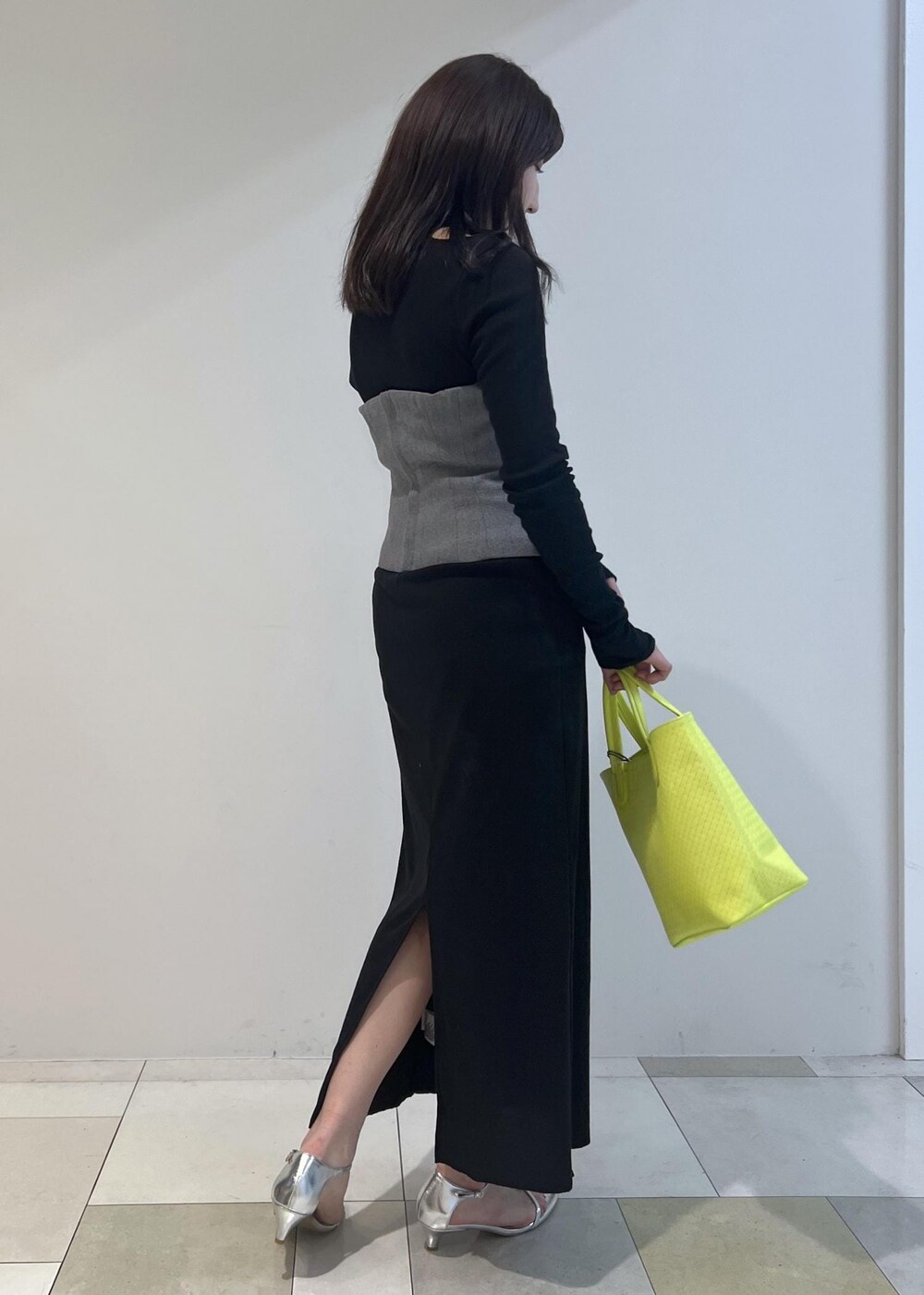 シルバー系のサンダル、ブラック系のワンピース、グリーン系のトートバッグを着用したレディースの春コーディネートの2枚目の写真