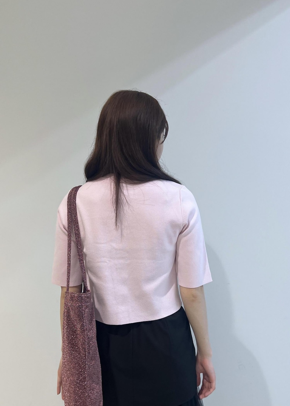 ブラック系のローファー、ブラック系のスカート、ピンク系のトートバッグを着用したレディースの夏コーディネートの3枚目の写真