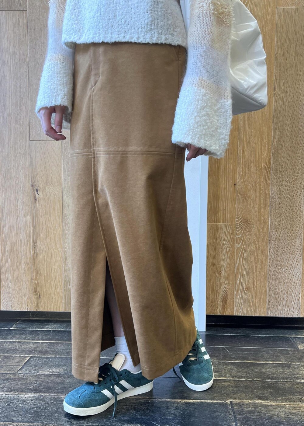 ホワイト系のニット/セーター、ホワイト系のショルダーバッグ、イエロー系のスカートを着用したレディースの秋コーディネートの5枚目の写真