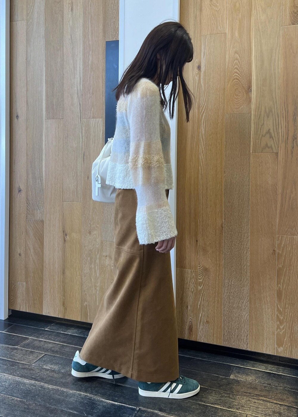 ホワイト系のニット/セーター、ホワイト系のショルダーバッグ、イエロー系のスカートを着用したレディースの秋コーディネートの3枚目の写真
