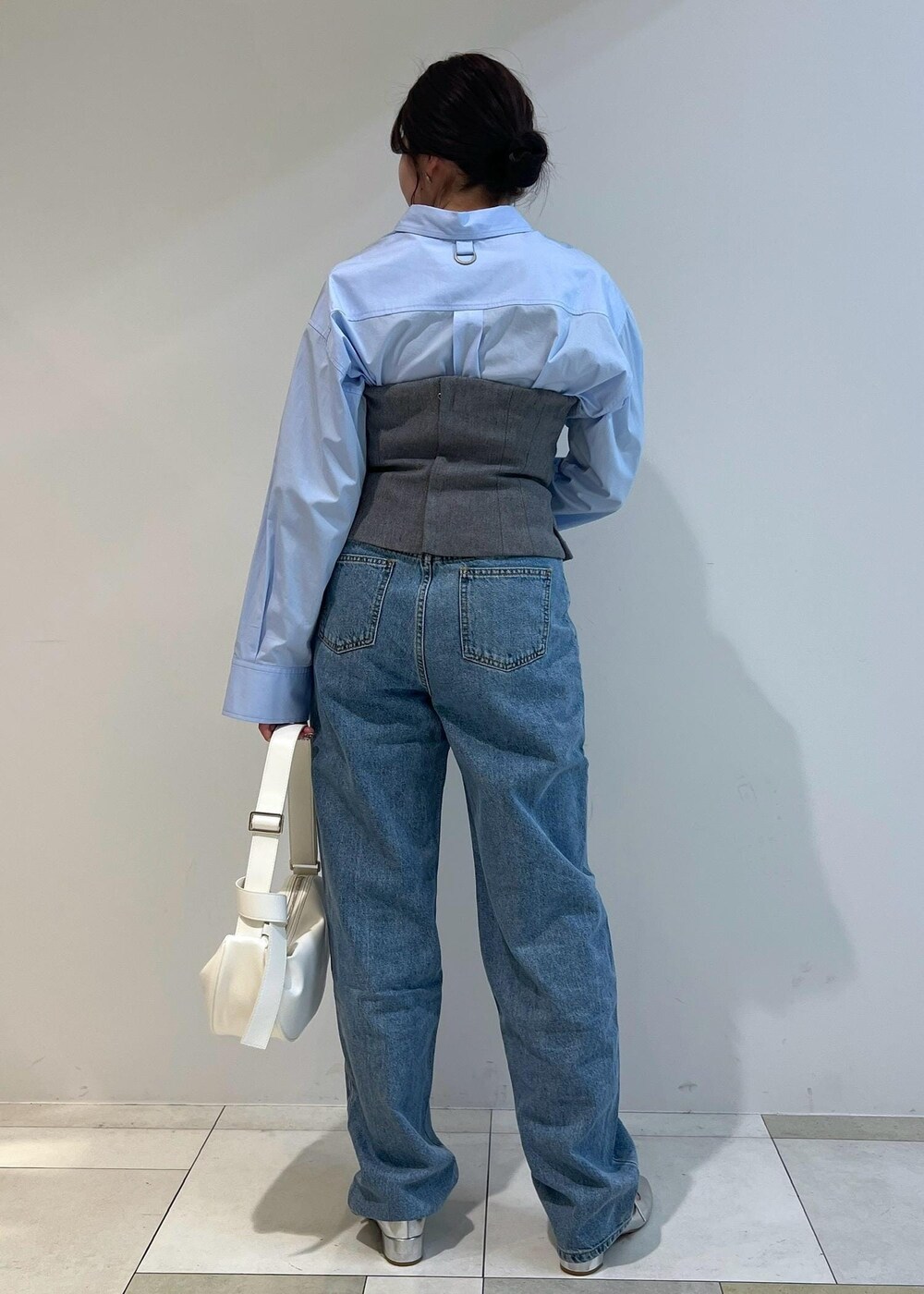 シルバー系のパンプス、ブルー系のシャツ/ブラウス、ホワイト系のショルダーバッグを着用したレディースの春コーディネートの3枚目の写真