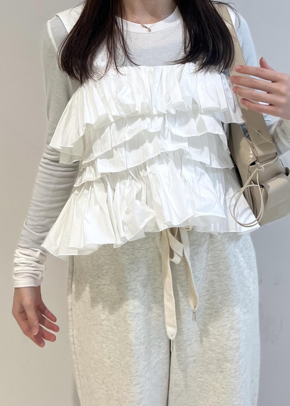 ホワイト系のスウェットパンツ、ベージュ系のショルダーバッグ、その他のバレエシューズを着用したレディースの冬コーディネートの4枚目の写真