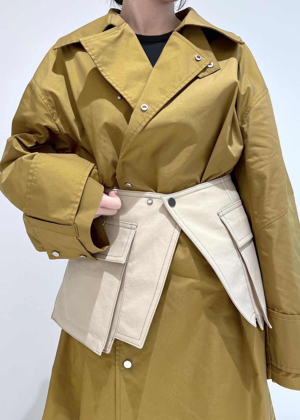 ブラウン系のステンカラーコート、ブラック系のパンプス、ベージュ系のベルトを着用したレディースの冬コーディネートの4枚目の写真