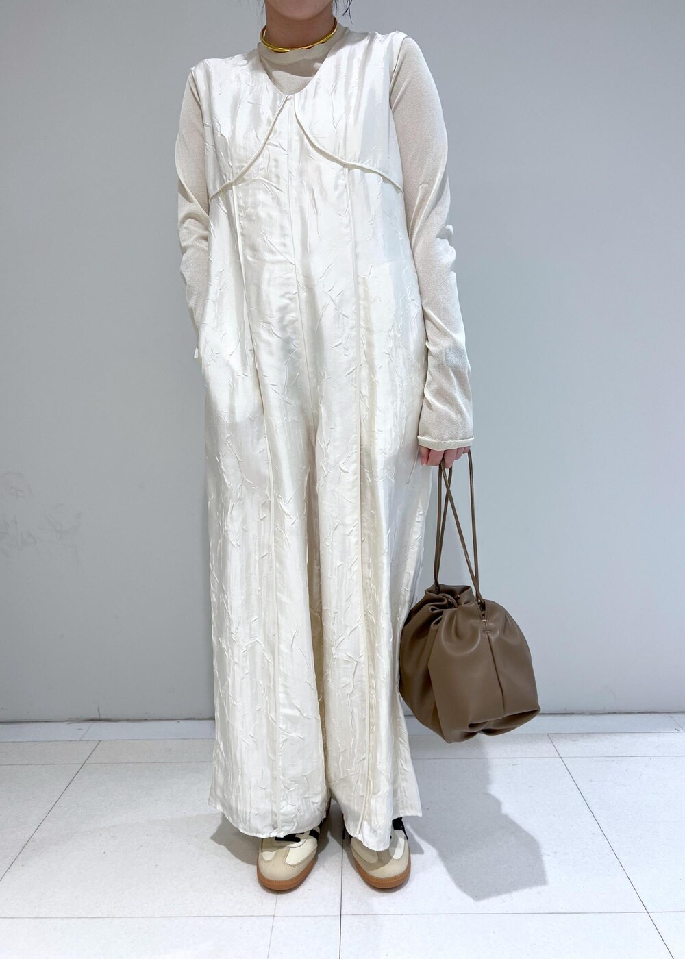 ホワイト系のTシャツ/カットソー、ブラウン系のショルダーバッグ、ホワイト系のつなぎ/オールインワンを着用したレディースの冬コーディネートの5枚目の写真